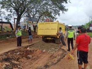 Tak Kunjung Diperbaiki, Anggota Polsek Tapung Hulu Dibantu Warga Timbun Jalan yang Rusak Parah