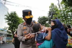 Kapolda Jatim Bagikan Beras dan Kenakan Masker Pada Anak Kecil yang Tak Kenakan Masker